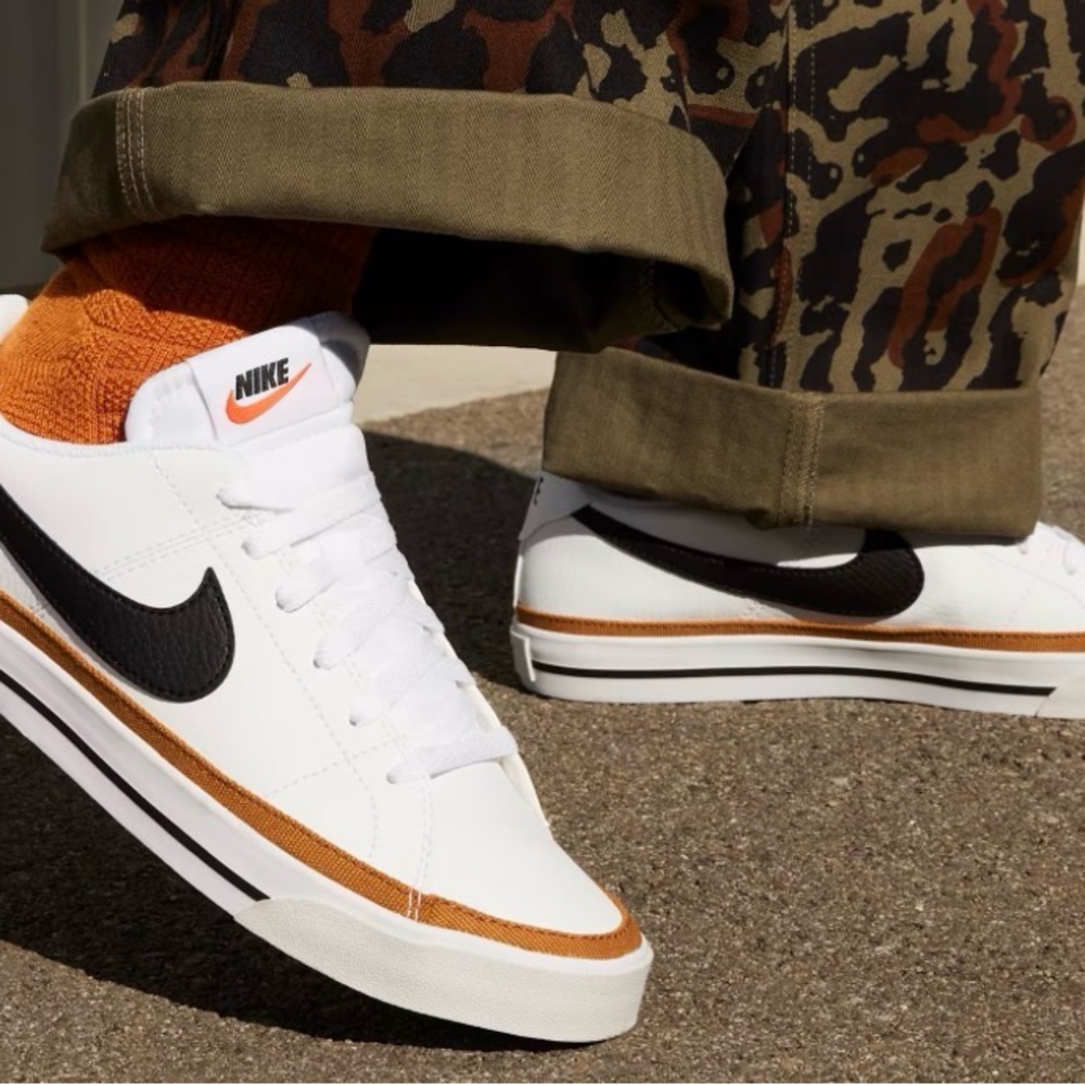 Nike White Low-Top Sneakers with Black Swoosh and Orange Accents